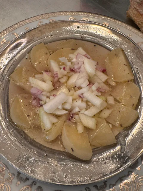 Kartoffelscheiben mit gehackten Zwiebeln und Dressing