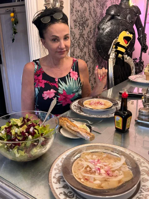 Michi an einem Tisch mit Salat, Brot und Tellergerichten
